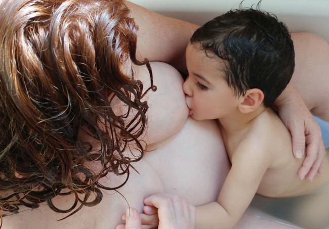 Gael alimentándose en la bañera el pecho de su mamá Tatiana.