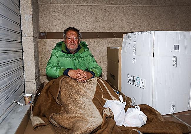 José se protege del frío con unos cartones.