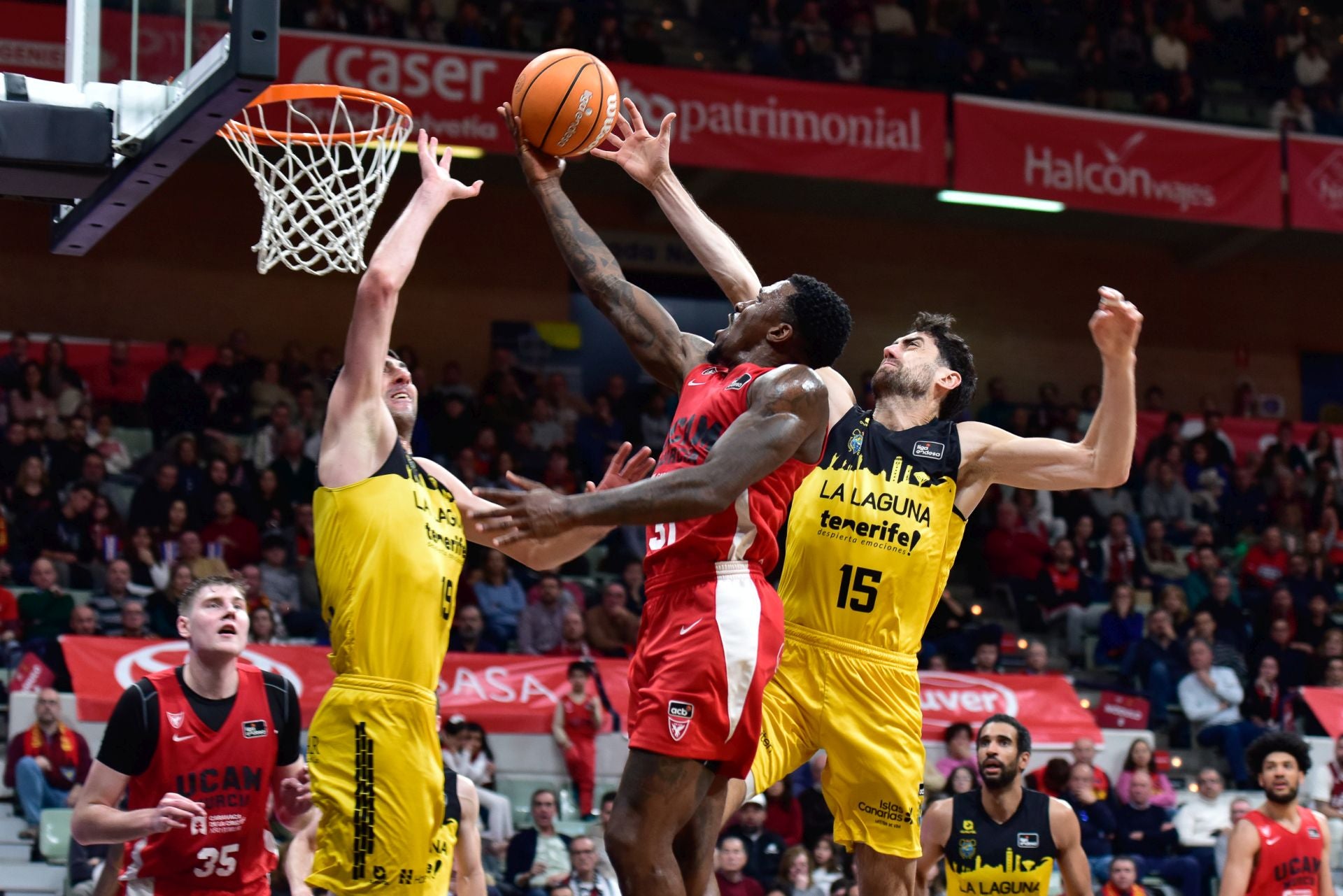 Dylan Ennis, estrella del UCAM Murcia, entra a canasta entre Shermadini y Sastre.