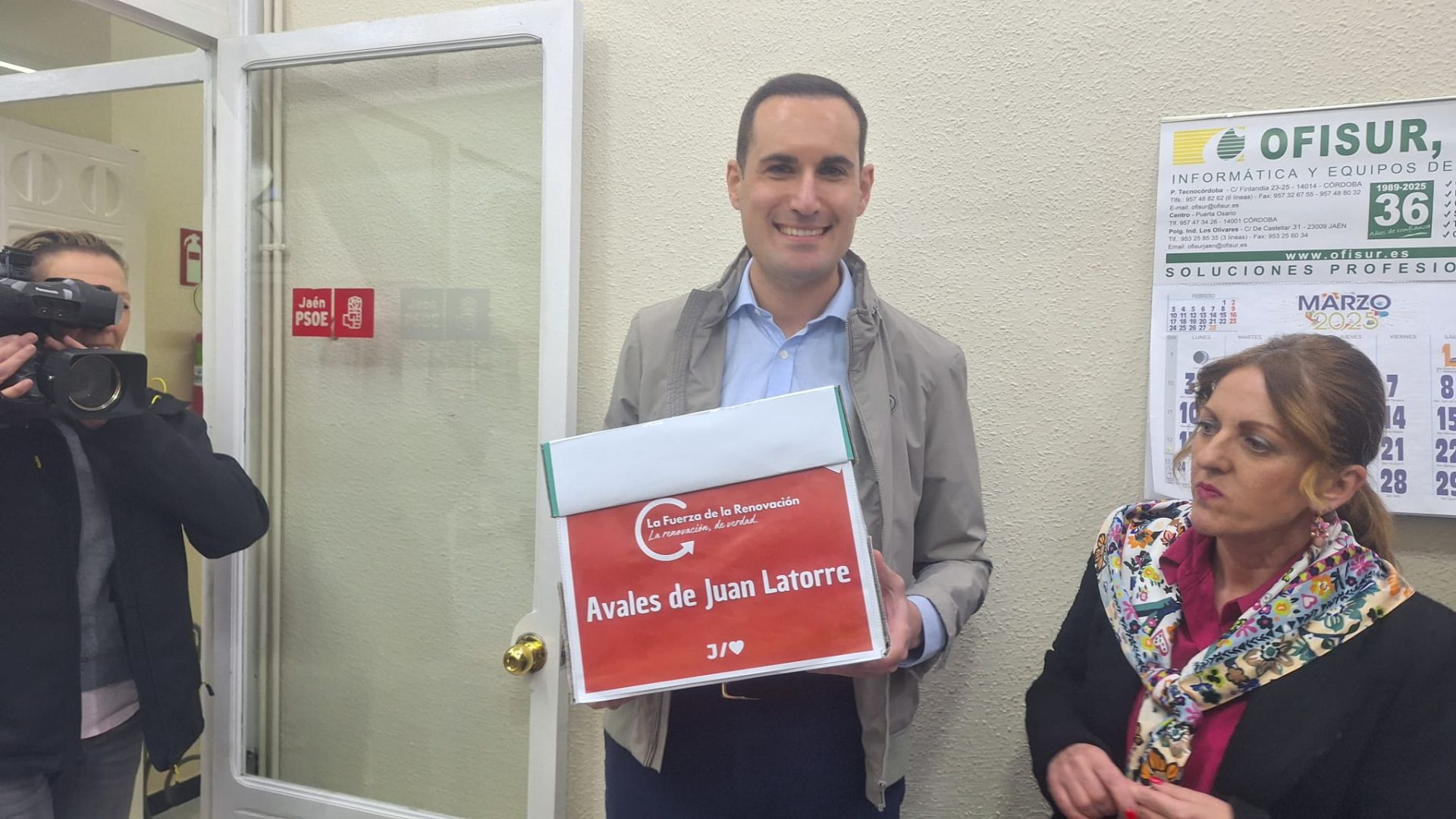 Juan Latorre posa con una caja con avales, rodeado de un gran número de militantes.