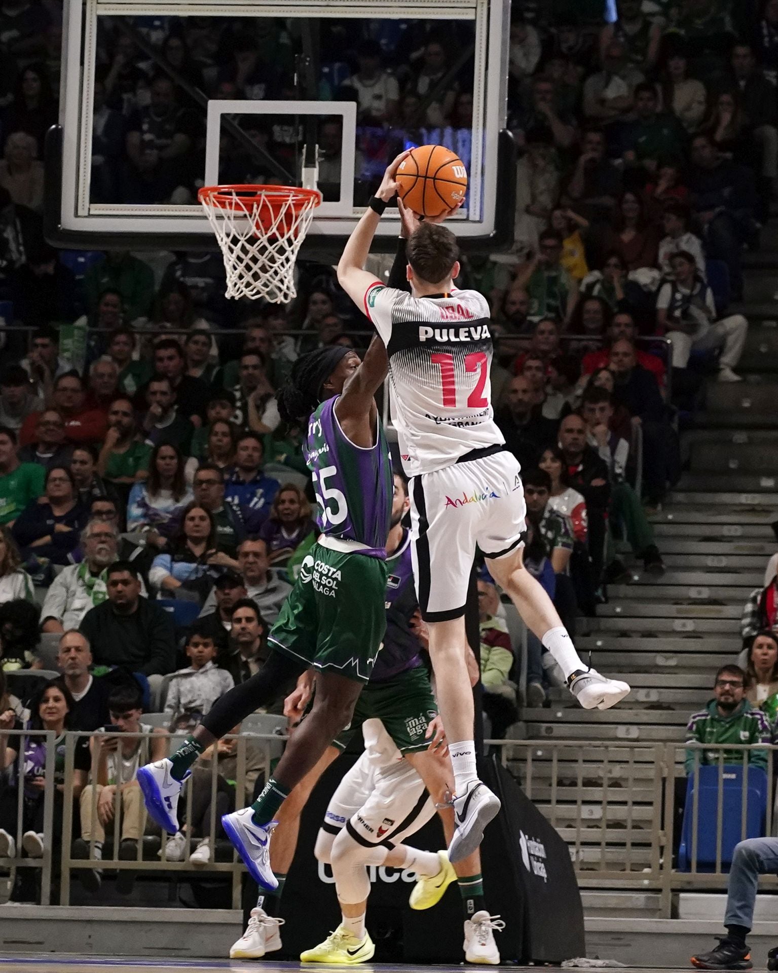 Acción durante el duelo entre el Unicaja y el Covirán en el pabellón Martín Carpena, aquí Agustín Ubal lanza con mucho descaro ante Perry.