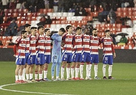Los futbolistas del Granada se abrazan durante el minuto de silencio.