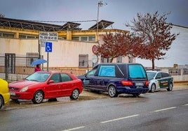 Entrada del coche fúnebre en el tanatorio de Guadahortuna bajo una intensa lluvia.