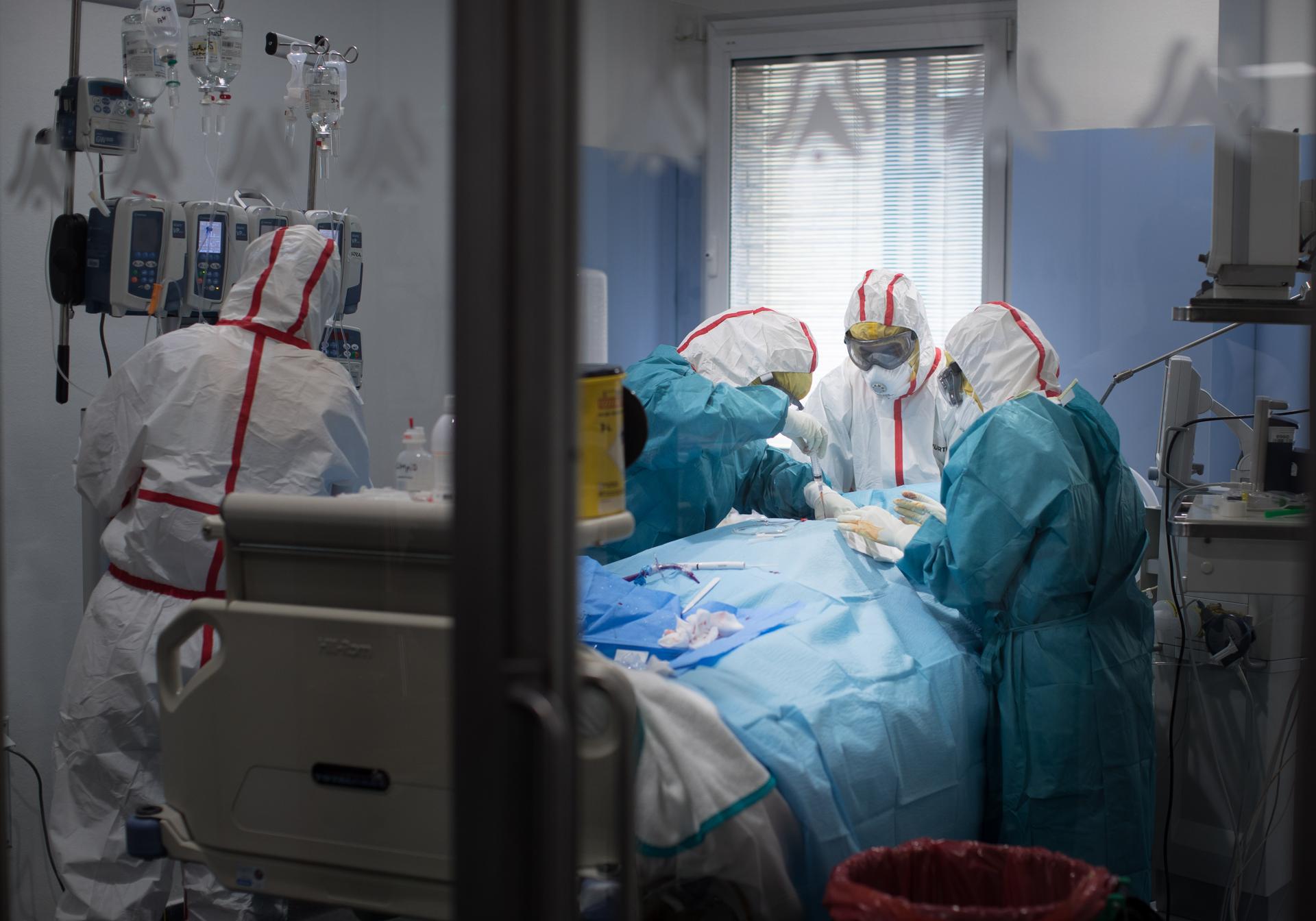 Sanitarios atienden a un enfermo de covid en la UCI del Virgen de las Nieves.