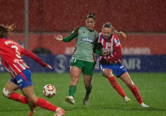 La nazarí Postigo, de verde. roba el balón ante el Atlético.