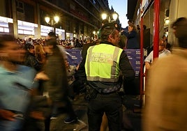 Agente de la policía local de Granada patrulla en la noche del Martes Santo de la Semana Santa granadina.