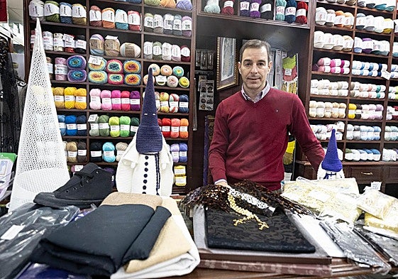 José F. Sáez, tras el mostrador de Mercería Sáez, donde los hilos, las lanas y los elementos de costura se entremezclan con la cultura cofrade.