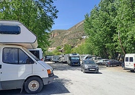 Autocaravanas en el aparcamiento de la calle Huenes, junto al río, en el casco antiguo de Monachil.