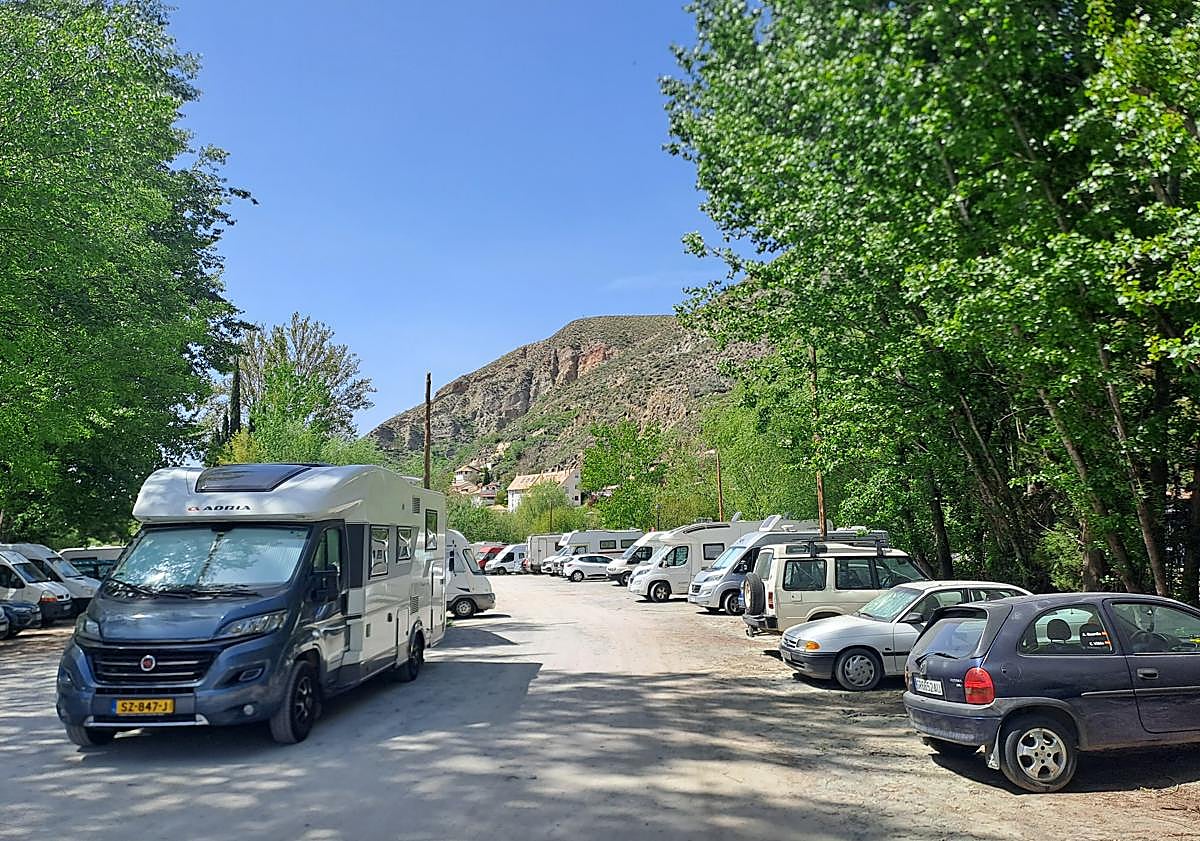 Imagen principal - Autocaravanas en el aparcamiento y en la calle Huenes, junto al río Monachil.