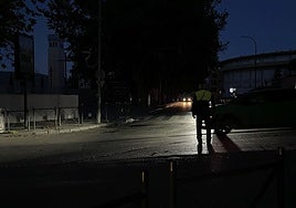 Un policía local regula el tráfico en la avenida de Granada, junto a la plaza de toros, en la noche del apagón.