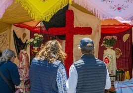 Personas observan una Cruz de mayo.