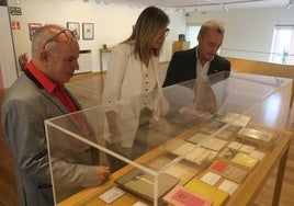 Claudio Pérez, Poli Servián, de Fundación Caja Rural Granada, y Raúl Manrique, ante una vitrina.
