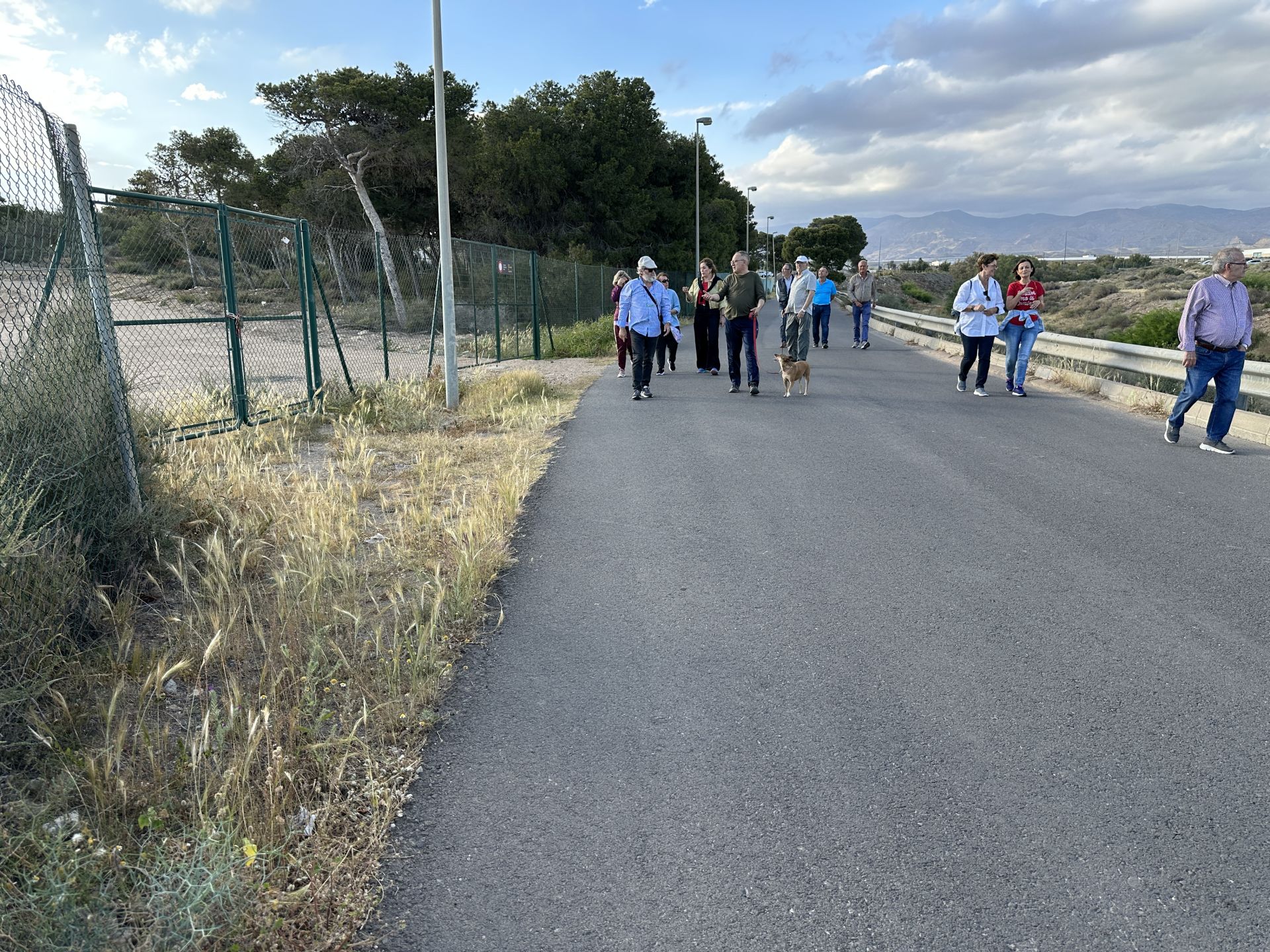Vecinos caminan por el camino que lleva a la playa de El Alquián.