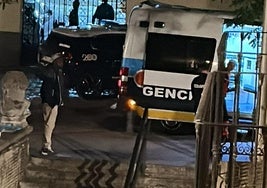 La ambulancia, junto a un coche de Policía Nacional, atiende en la calle Palacios al herido en la trifulca.