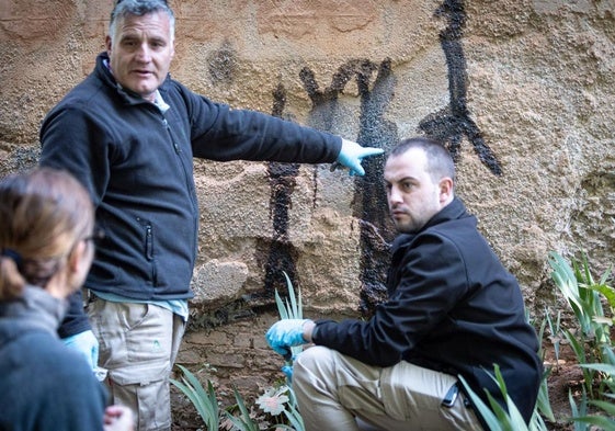 Operarios de la Alhambra borrando las pintadas que aparecieron el pasado viernes.