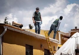 Agentes de la Guardia Civil inspeccionan el tejado de la vivienda.