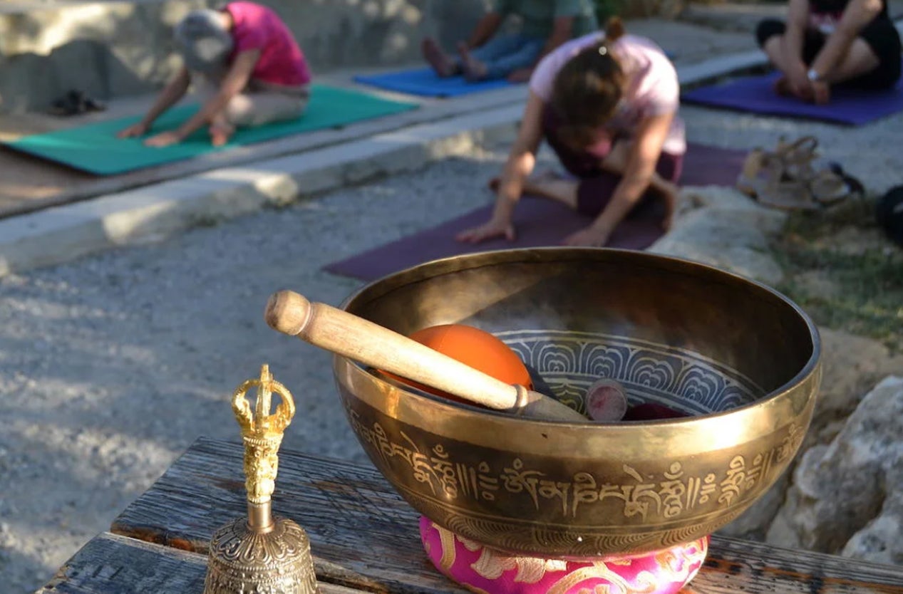 Un grupo de personas practican yoga al aire libre.