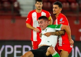 Karrikaburu, delantero del Racing, cae sujeto por un futbolista del Almería.