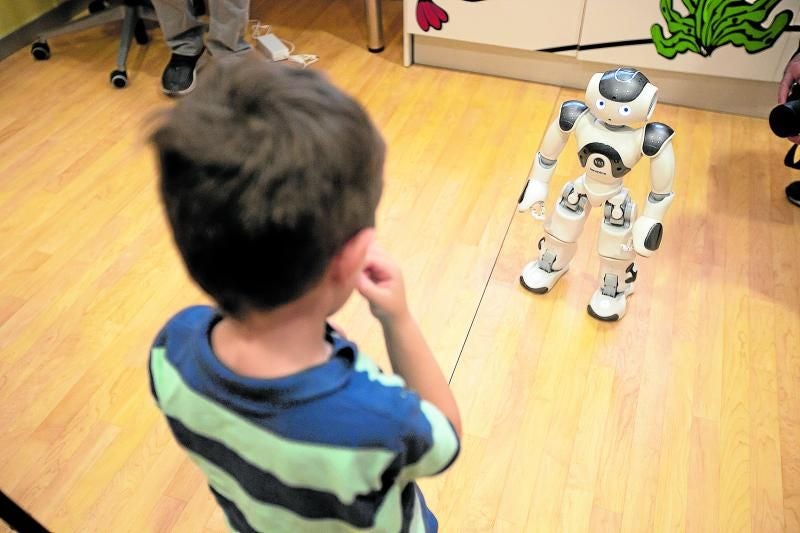 Un niño juega con un robot en un centro de Atención Temprana.