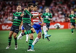 Germán Sánchez despeja un balón ante Matías Arezo durante su vuelta a Los Cármenes en 2022.