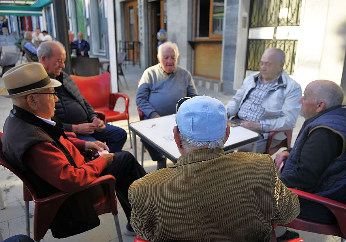 Vecinos de Órgiva jugando a las cartas para entretenerse y tomando el fresco en la Plaza García Moreno.