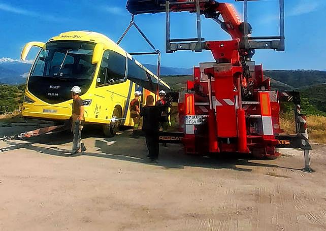 Una grúa asegurando el bus.