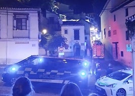 Vehículos policiales y de los Bomberos en el Peso de la Harina. Arriba a la izquierda, las llamas en el tejado.