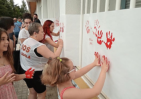 Los vecinos estampan sus manos para constatar su denuncia.