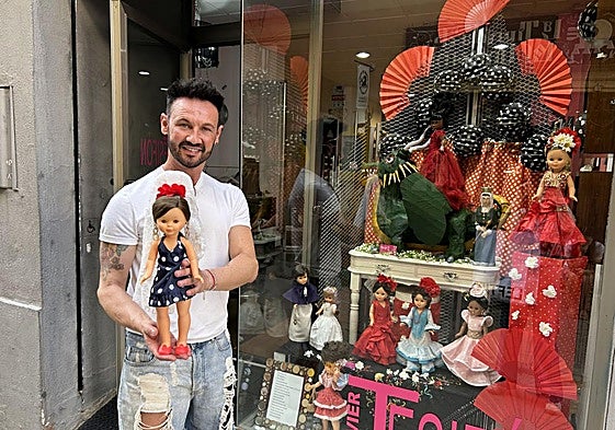 El peluquero sujeta a una de sus Nancy frente a su escaparate.