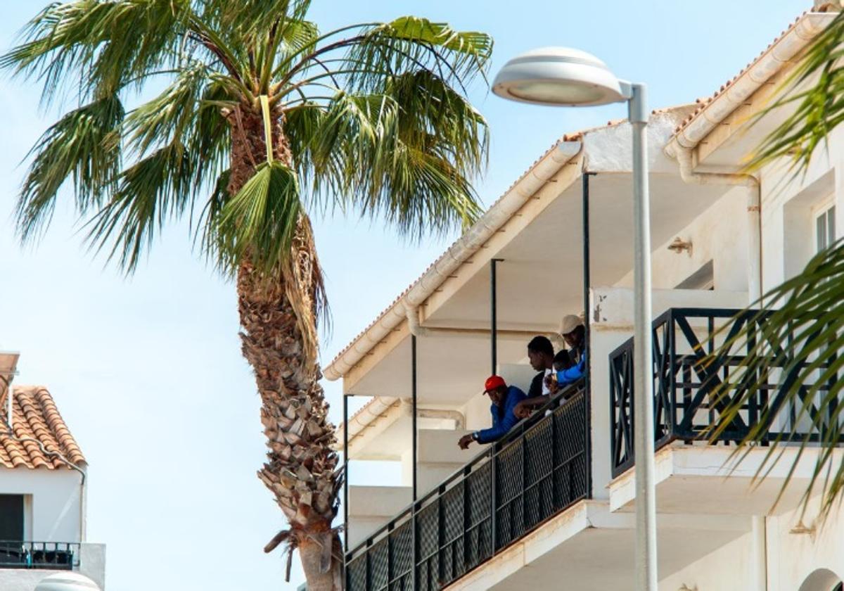 Un grupo de migrantes, asomados al balcón del hotel.