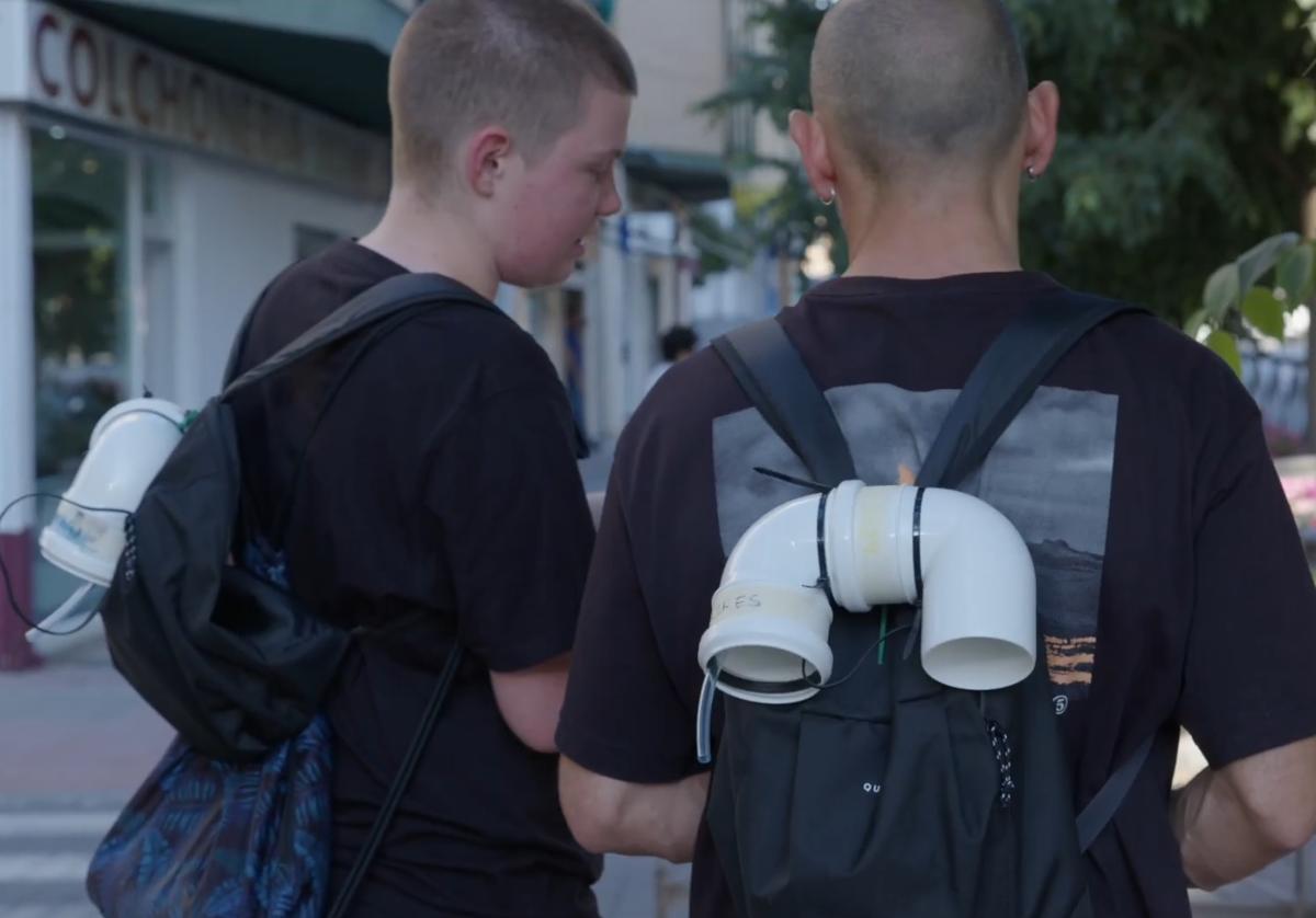 Dos voluntarios con su sensor en la mochila toman datos de un árbol de Granada.