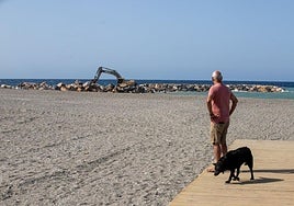 Un viandante observa las obras del espigón de Playa Granada en Motril.