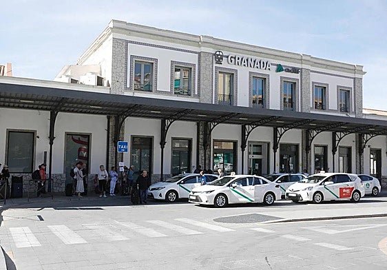 Taxis y viajeros junto al antiguo edificio de la estación.