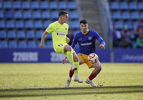 Casadesús, de azul, presiona a un rival en un partido.