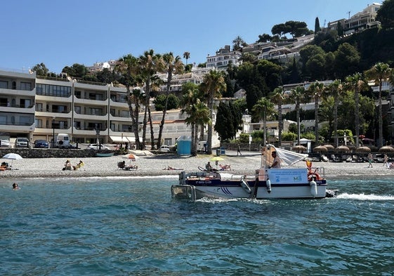 Rafa navega con el barco limpia playas de Almuñécar.