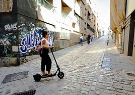Una usuaria de patinete sube por la Cuesta del Pescado.