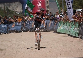 David Valero apura los últimos metros con una bandera de Andalucía bajo los aplausos de sus vecinos.
