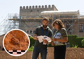 Los arqueólgos de la Alhambra, Fernando Martínez y Paz Gázquez, que trabajan en esta investigación. Y en el círculo, el hueso de melocotón incrustrado en uno de los muros del Mexuar. ideal