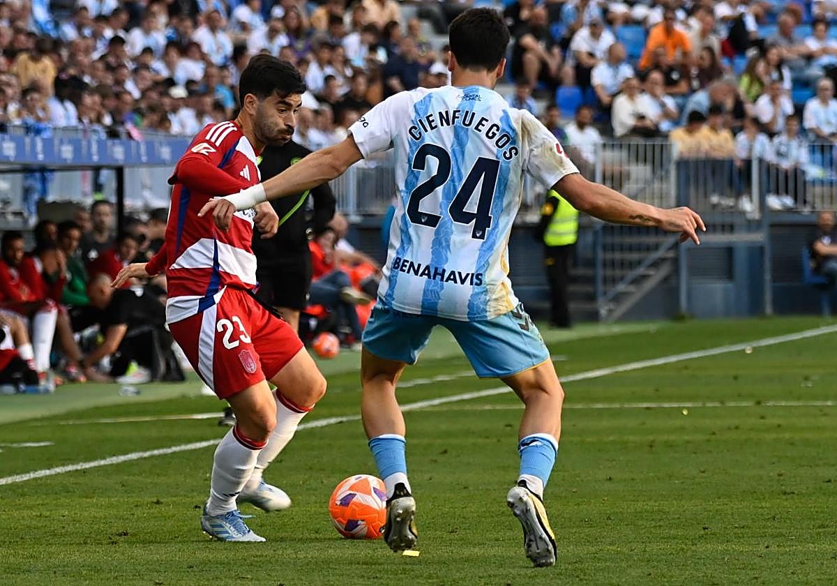 Manu Trigueros juega un balón ante la presión de un futbolista del Málaga en La Rosaleda.