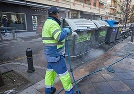 Un operario del Ayuntamiento limpia unos contenedores en las calles de Granada.