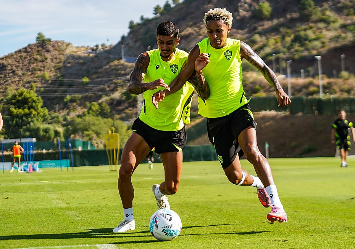 Chumi y Lázaro disputando un balón dividido en un entrenamiento.