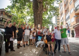 Vecinos y comerciantes de la avenida de Cervantes rodean uno de los árboles que pueden ser talados