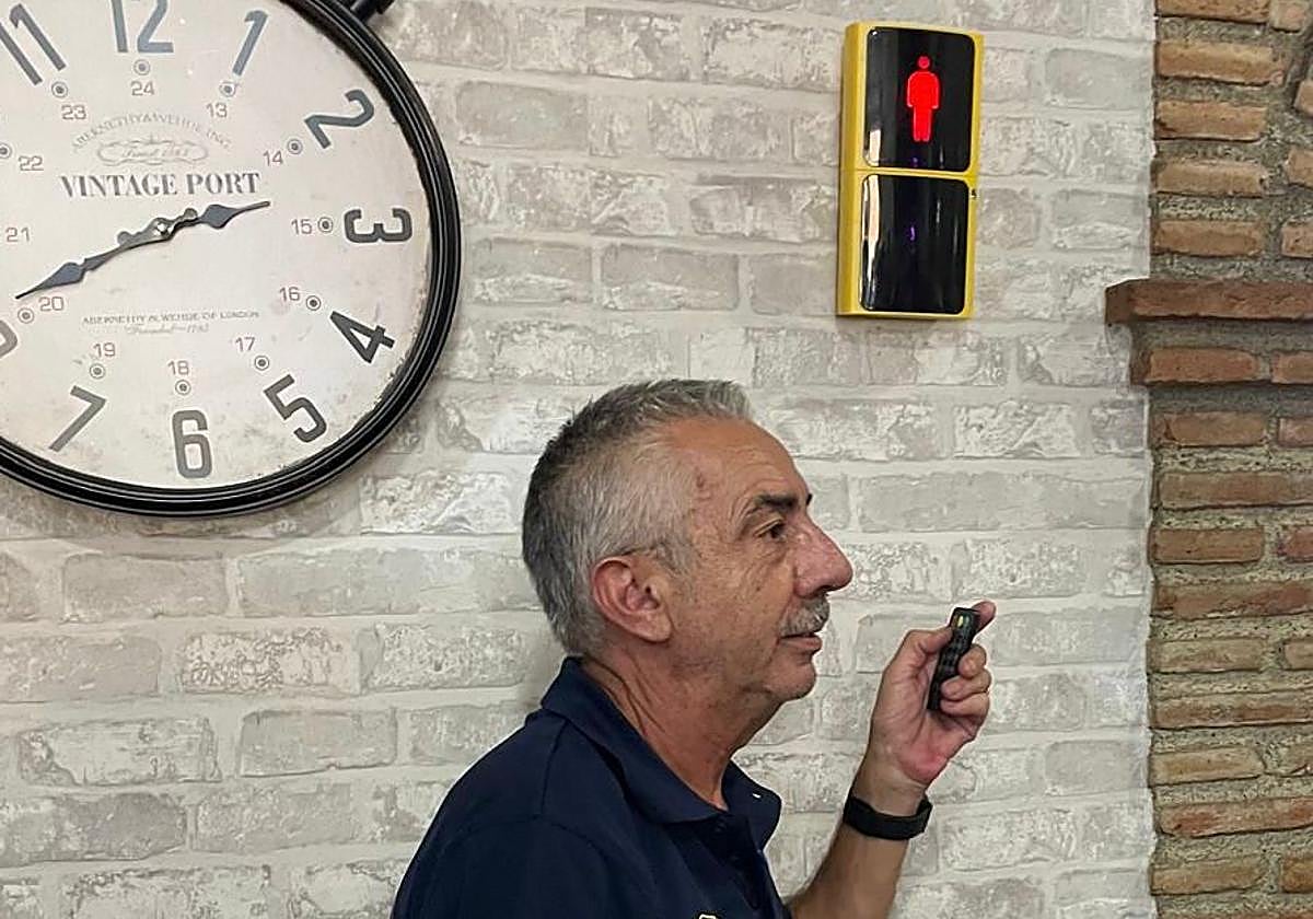 José Luis, propietario del Mesón Baena, junto al semáforo que ha instalado en su negocio.
