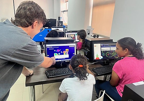 Un cibervoluntario atiende a una niña en una de las sesiones de Campamento Digital.