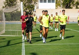 Jugadores del Almería corriendo junto a Manel, uno de los entrenadores. UDA