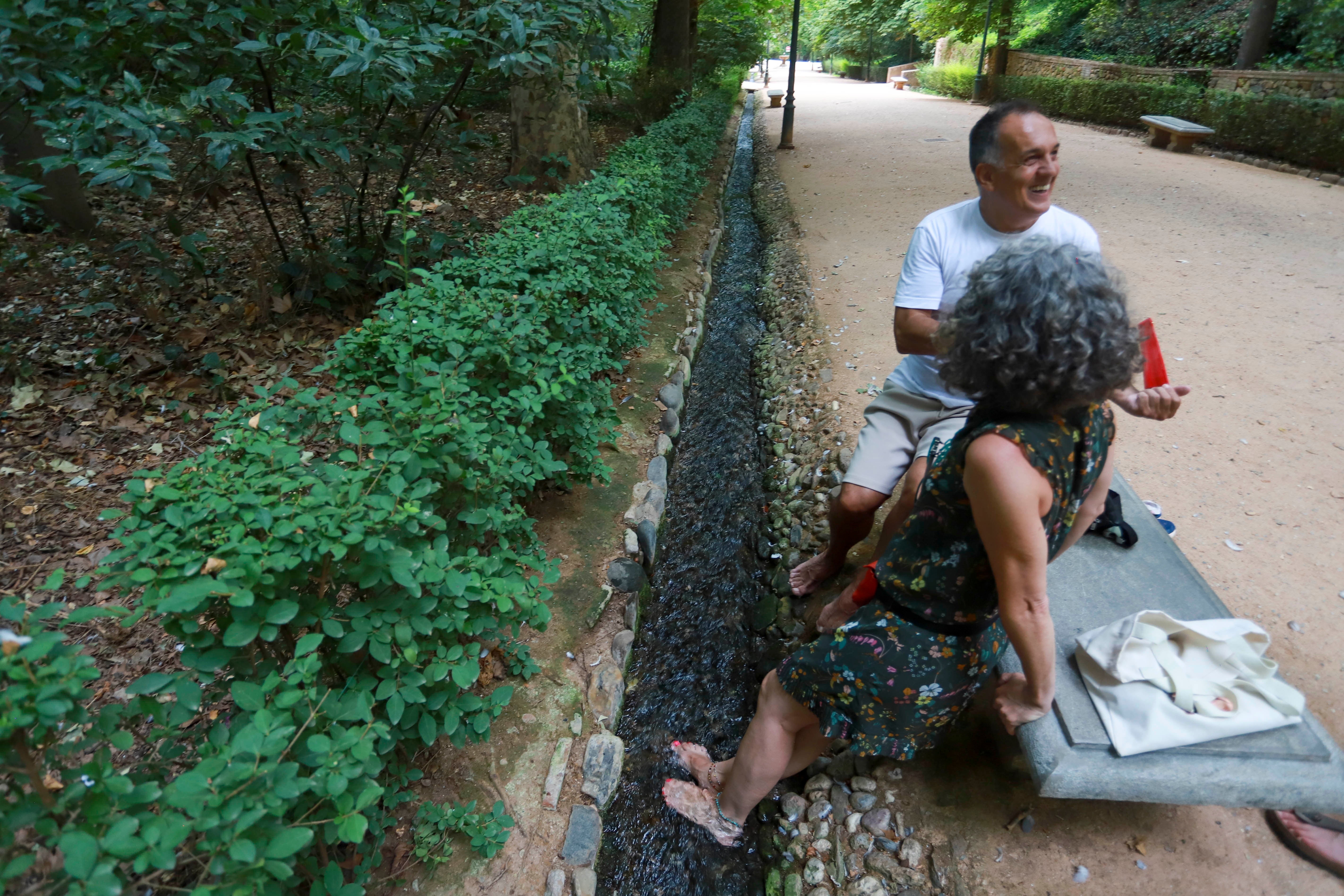 Monse y Paco metiendo los pies en la acequia
