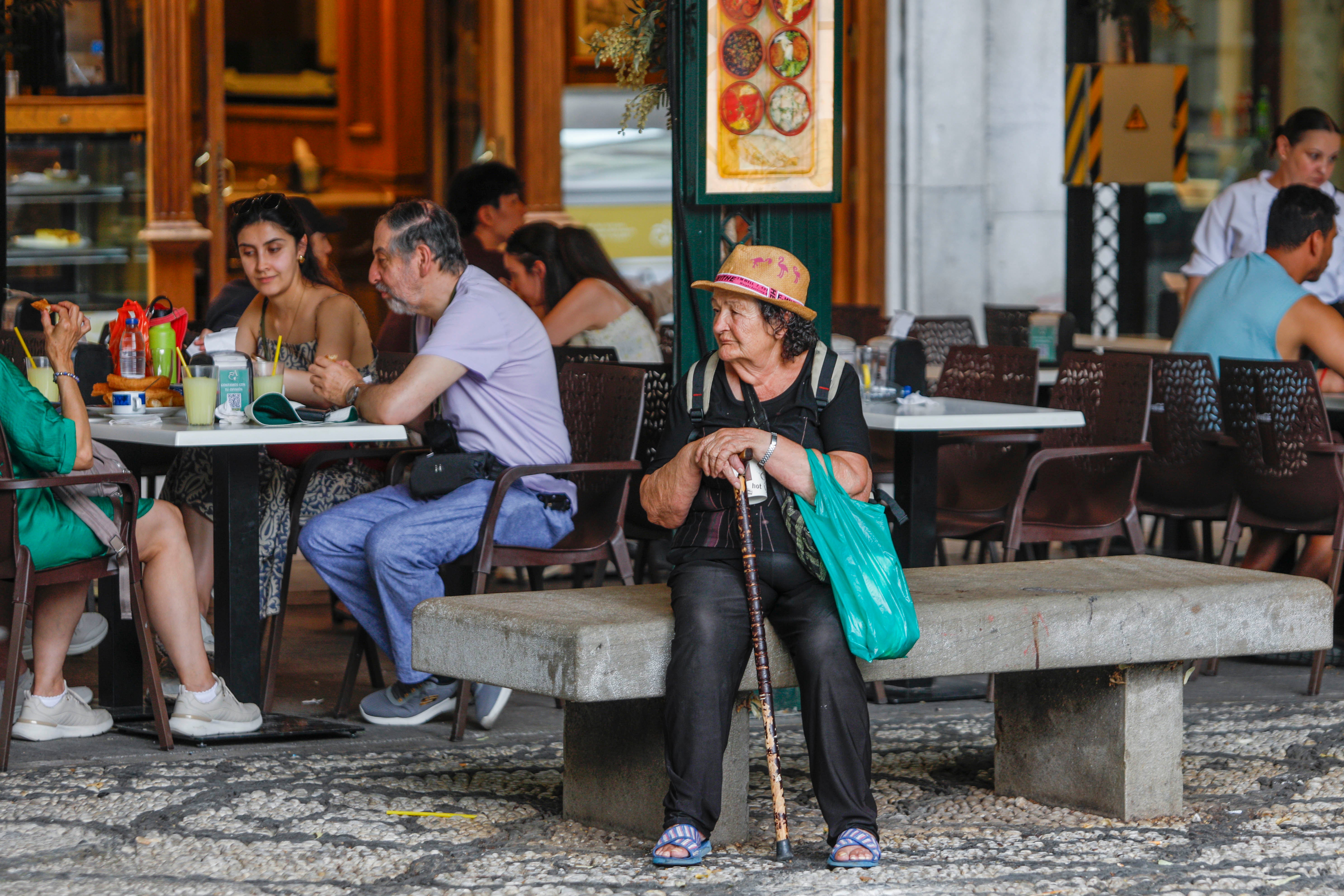 Mujer sentada en un banco a la sombra