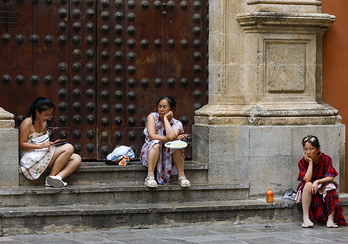 Tres turistas descansando en los escalones