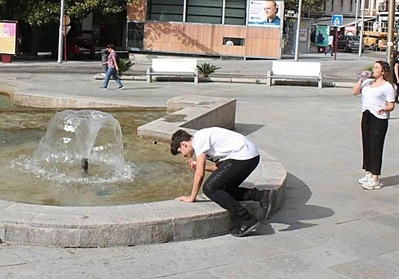 Un joven se refresca en la fuente de la plaza de la Constitución de Jaén, en una imagen de archivo.
