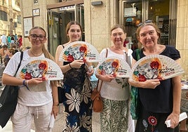 Una de las múltiples familias que acuden para conseguir los preciados abanicos de la Feria de Almería posan con este